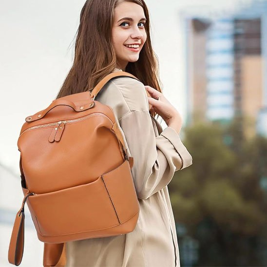 jeune femme avec un sac à dos ZenMaman marron, en direction de la garderie, affichant un sourire chaleureux qui évoque organisation, douceur et élégance dans le quotidien familial