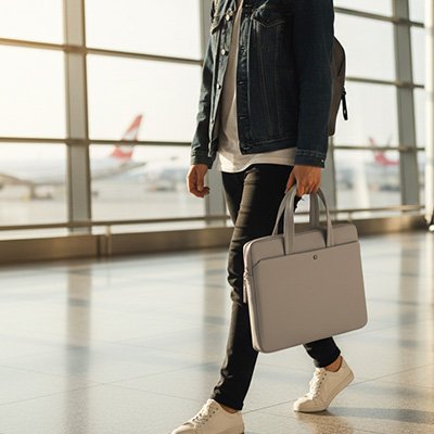 Homme à l'aéroport en direction de l'embarquement avec Sacoche ordinateur grise