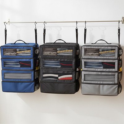 Organisateur de valise suspendu avec plusieurs compartiments en filet, idĂ©al pour ranger vĂȘtements et accessoires lors dâun voyage organisĂ©.