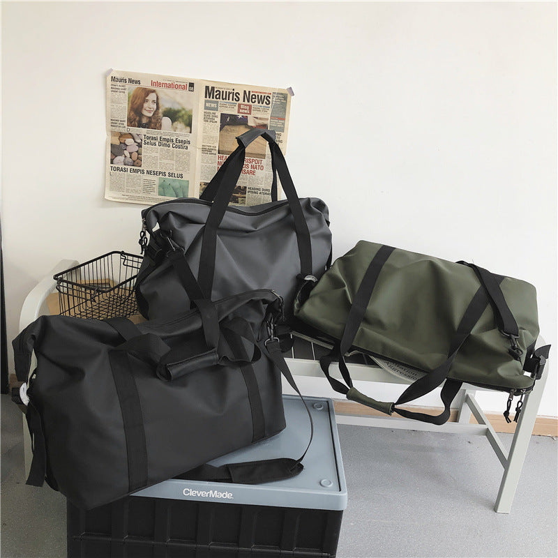 Sac week end noir gris et vert présentes ensemble en intérieur sur du mobilier pour montrer la collection sur un banc