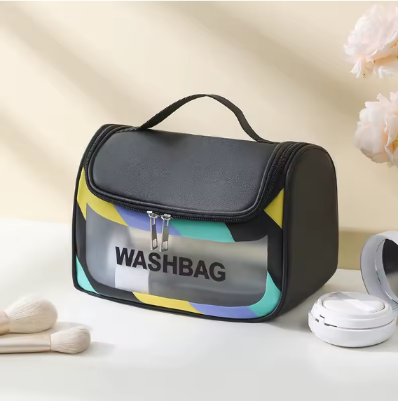 Trousse de toilette voyage noire design moderne, posée sur table lumineuse avec accessoires beauté, style épuré.