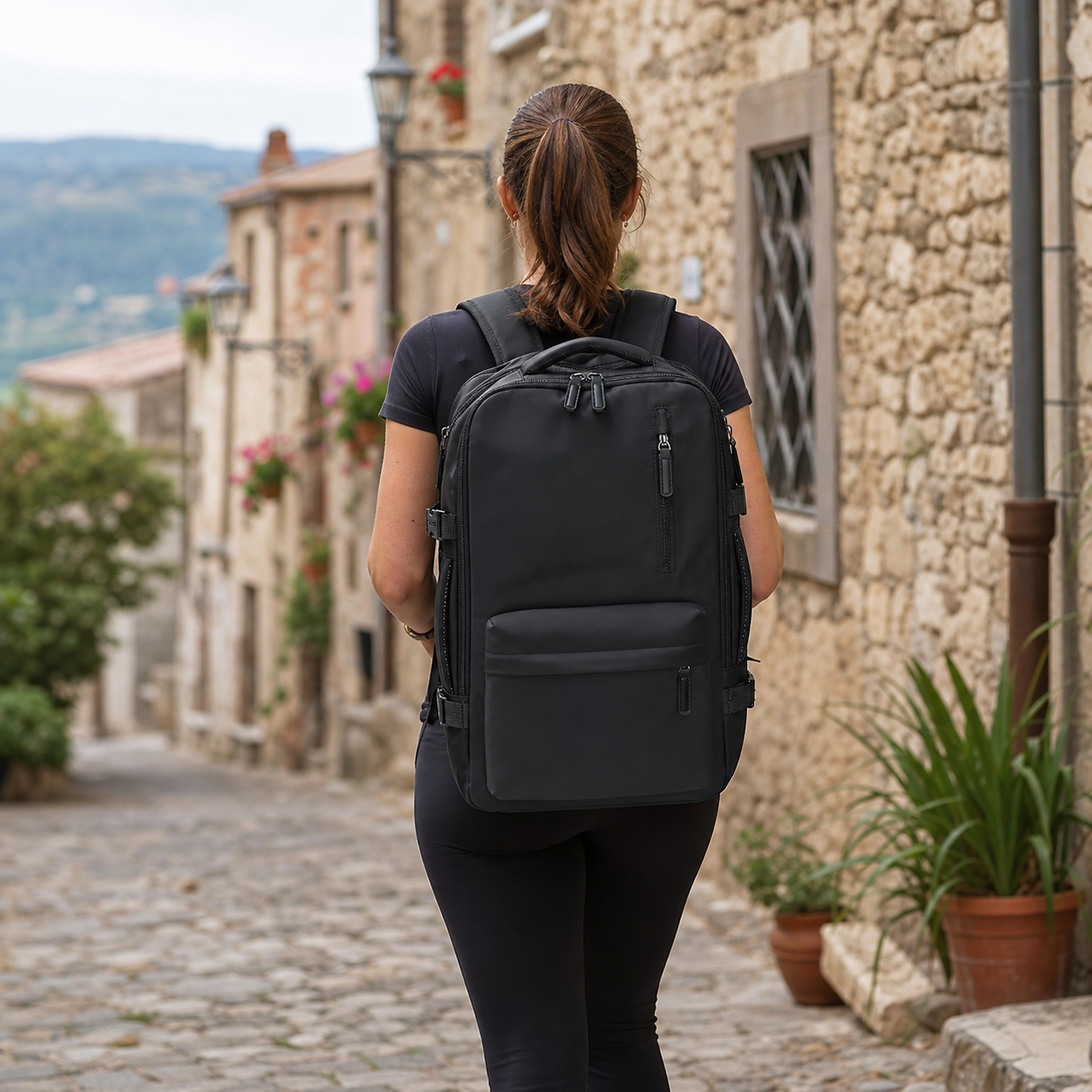 Femme avec sac bagage cabine dans une ruelle de Sardaigne