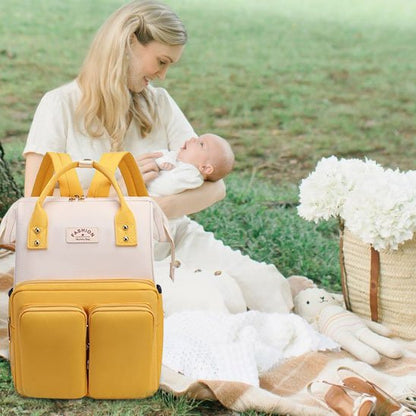 Jeune maman dans un parc  avec le sac de voyage à dos bébé blanc et jaune