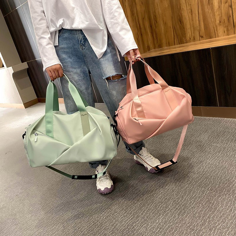 Personne tiens deux sac de voyage femme un rose et un vert couloir hotel