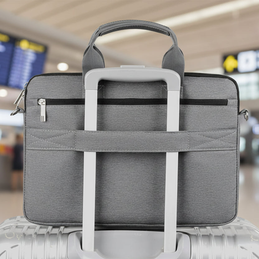 pochette ordinateur grise et robuste sur valise trolley et dans un décor d'aéroport