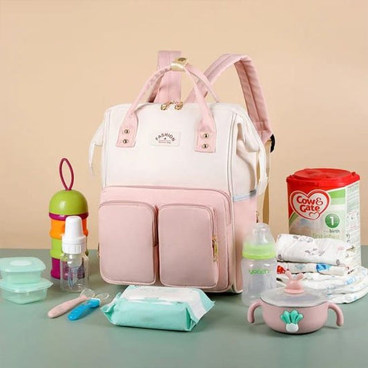 Présentation du sac de voyage à dos bébé sur petite table verte avec accessoires enfant