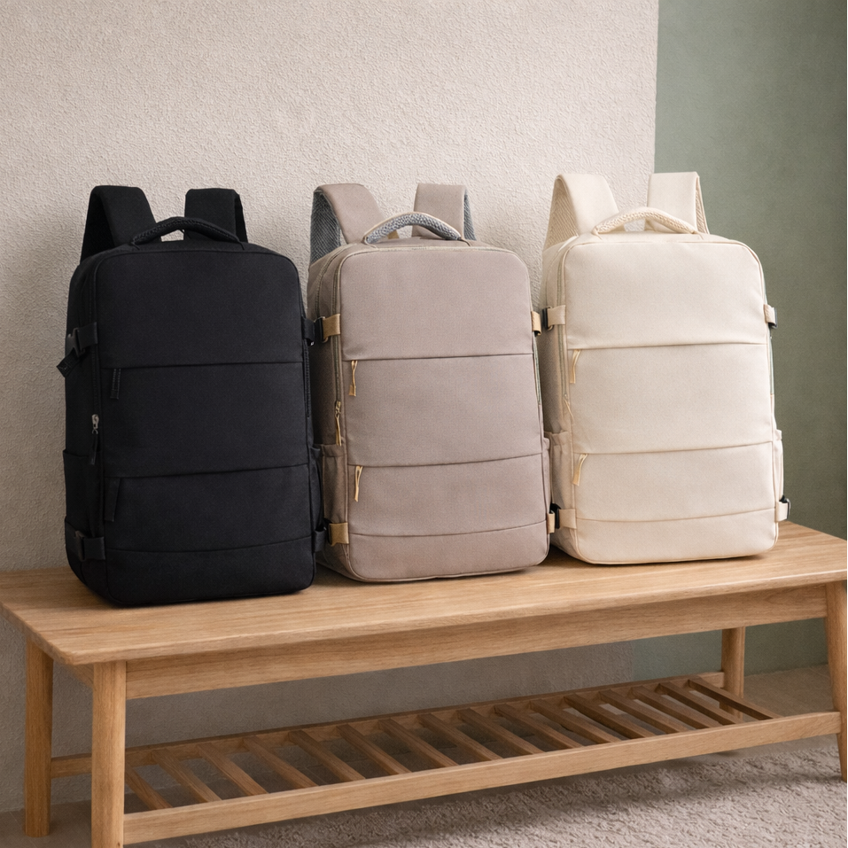Sac à dos de voyage ZEN cabine multifonction, en trois couleurs — noir, beige et blanc — posé sur un banc en bois,