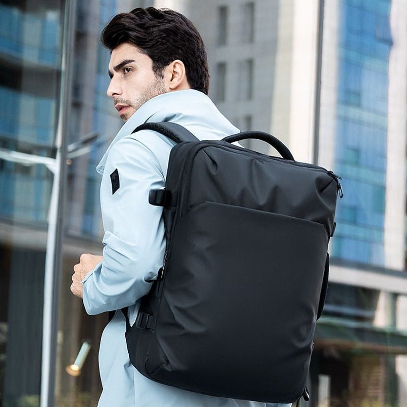 SAC A DOS DE VOYAGE noir style urbain porte par un homme en environnement professionnel idéal pour voyage affaires et bagage cabine
