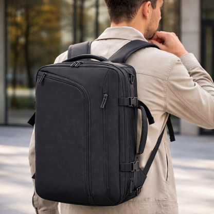 Homme de dos portant un sac à dos ordinateur portable ZenVoyage Business noir, design épuré et professionnel, en environnement urbain moderne.