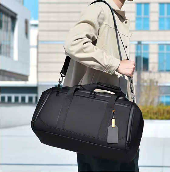 sac de voyages noir porte a l epaule par un homme en exterieur urbain