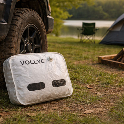 Sac sous vide de voyage pose près de 4x4 et tente de camping, format compact avec valve, idéal pour optimiser l'équipement en plein air