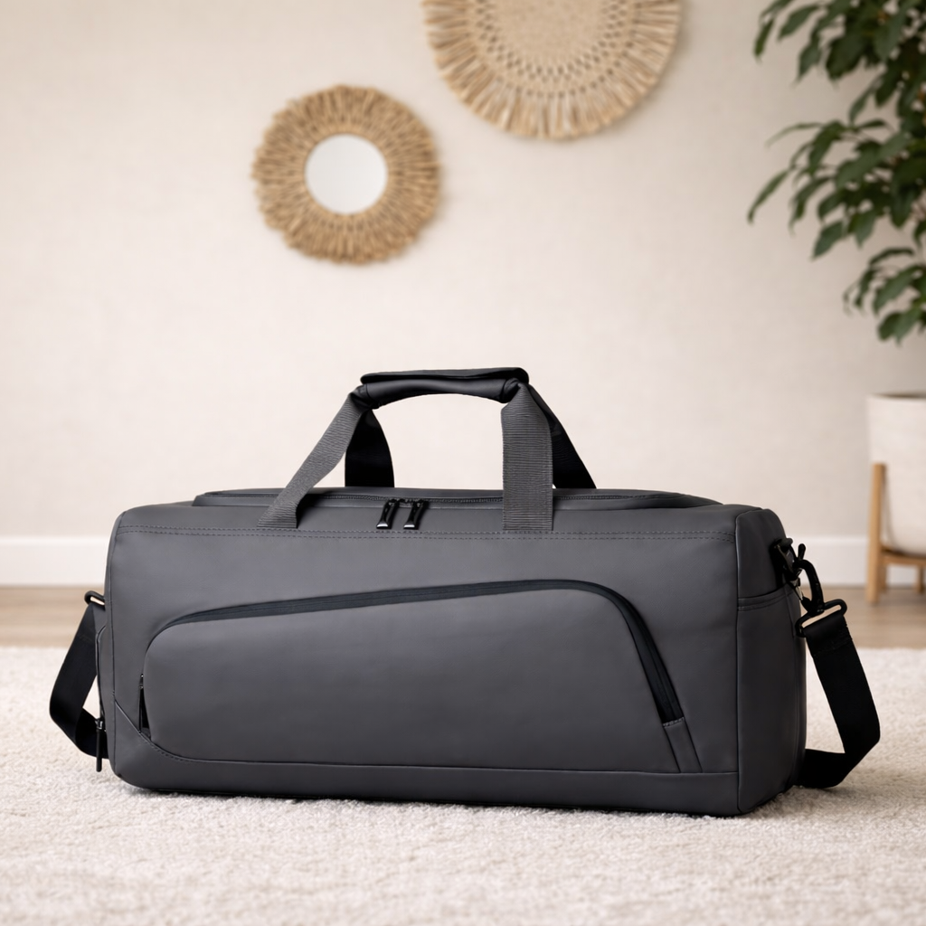 Sac weekend homme gris sur parquet en bois, lumière naturelle, avec plante verte et décoration murale bohème, style épuré
