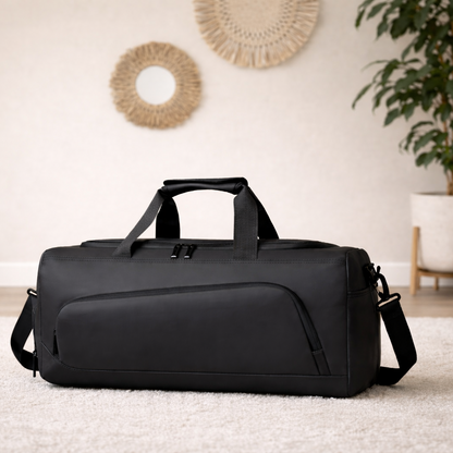 Sac weekend homme noir sur parquet en bois, lumière naturelle, avec plante verte et décoration murale bohème, style épuré