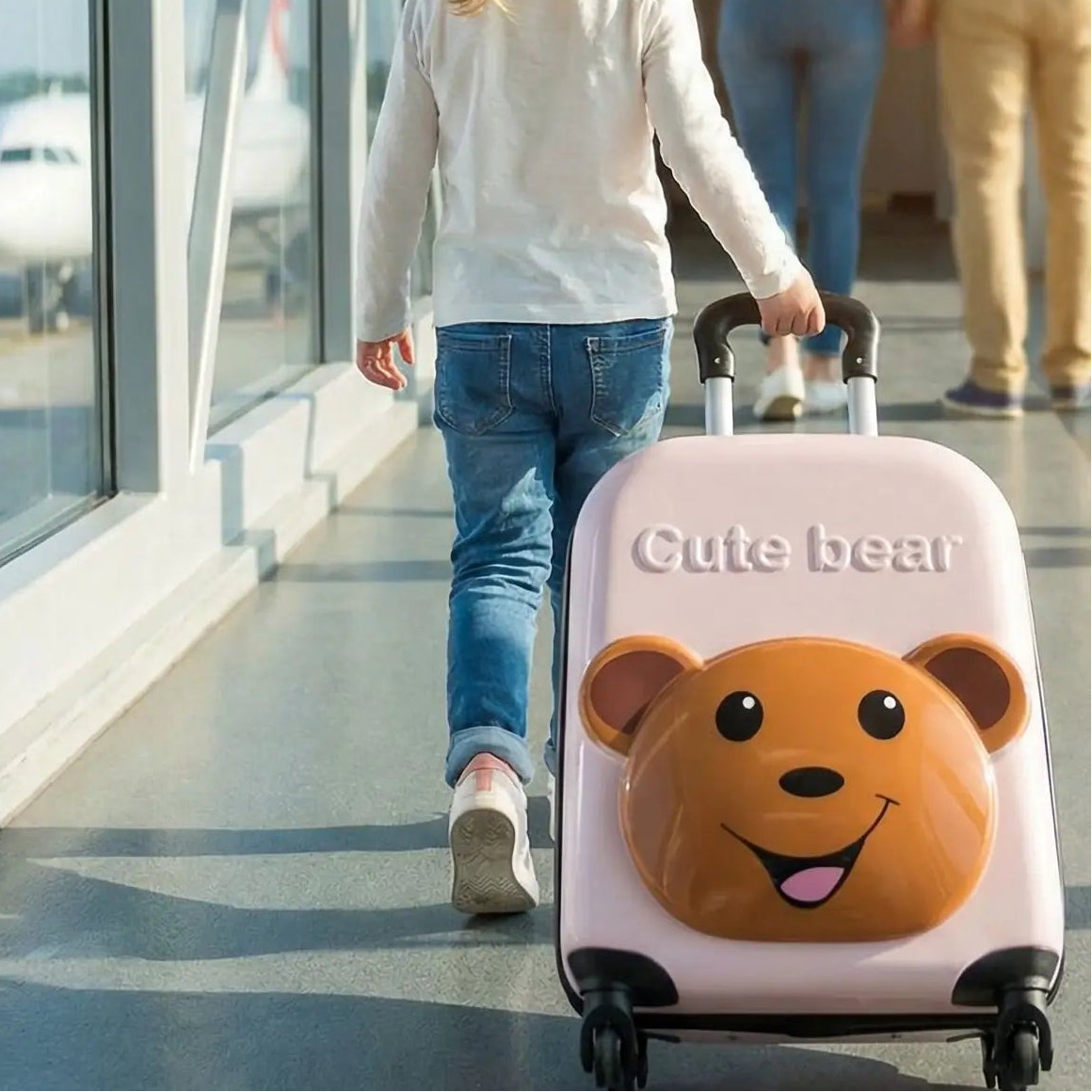 Départ de la petite aventurière avec ses parents et sa valise enfant rose avec petit ourson.
