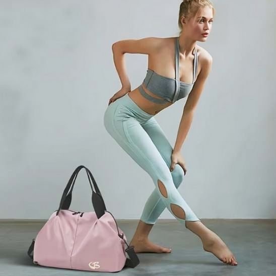 Femme élégante en position de ballerine, sac week end femme rose posé à ses pieds, style chic et féminin