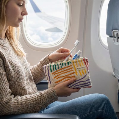 Femme en avion utilise une trousse de toilette en avion