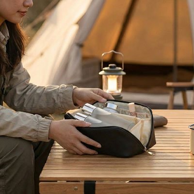 Femme présente l'intérieur compartimenté de sa trousse de maquillage Zen pratique qui loge tout son nécessaire beauté étant bien organisé