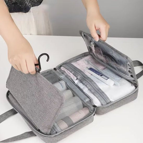 Femme referme sa Trousse de toilette femme grise pour un départ en escapade