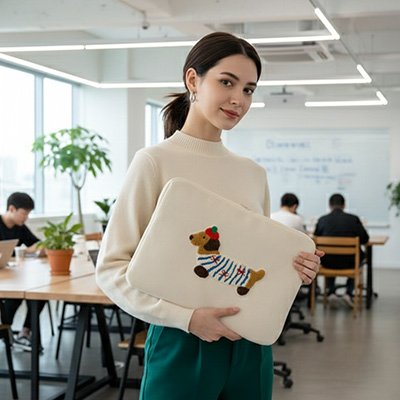 Femme tenant une pochette ordinateur avec motif chien dans un open space moderne, illustrant un usage professionnel et élégant.