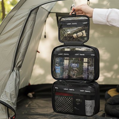 Grande trousse de toilette homme suspendue dans une tente, organisation parfaite et rangement optimisé