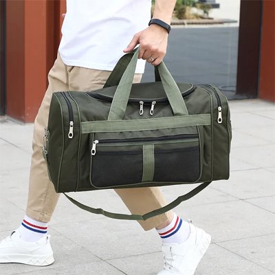homme transporte un sac week end vert et présente la poche externe