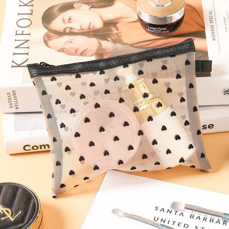 Moyenne pochette de maquillage blanche, posée sur une table de nuit en bois