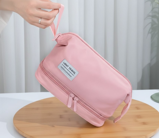 organisateur de maquillage léger rose tenu à la main présentation produit sur support bois minimaliste