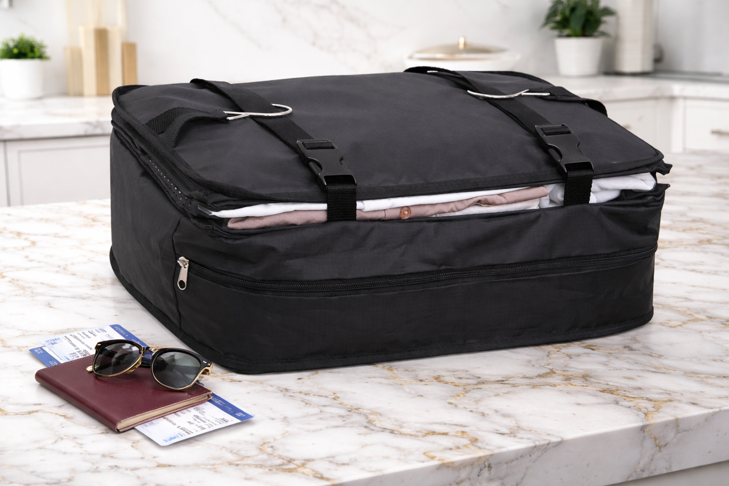 organisateur de valise noir compressé contenant des vêtements pliés, posé sur un plan de travail avec passeport et lunettes, prêt pour le voyage.