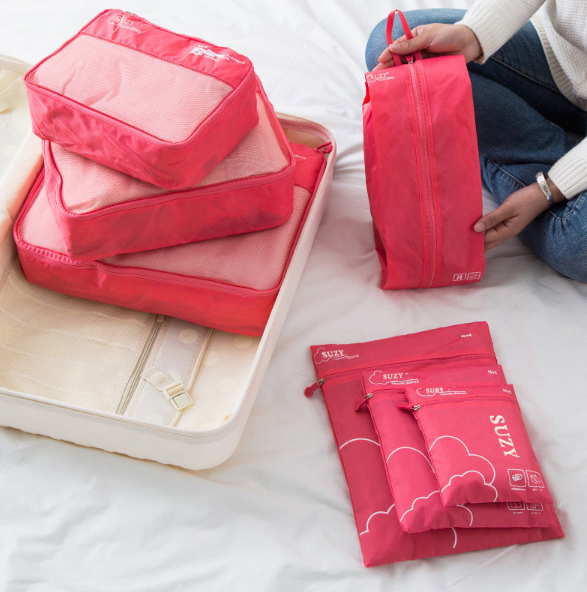 Packing Cube rose utilisé sur un lit avec valise ouverte, solution pratique pour trier et ranger ses affaires de voyage.