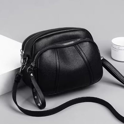 Petit sac à bandoulière femme noir sur table grise