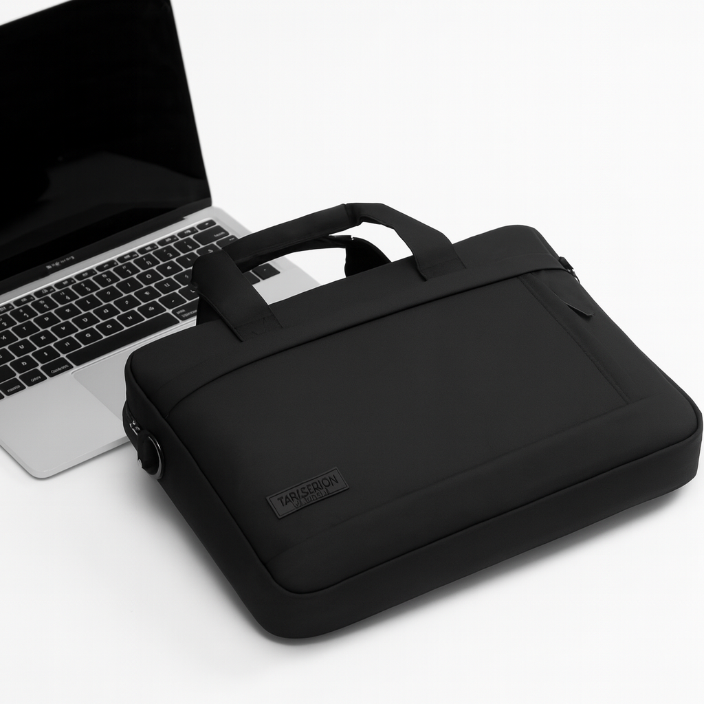 Pochette ordinateur noire placée devant un ordinateur portable sur fond blanc.