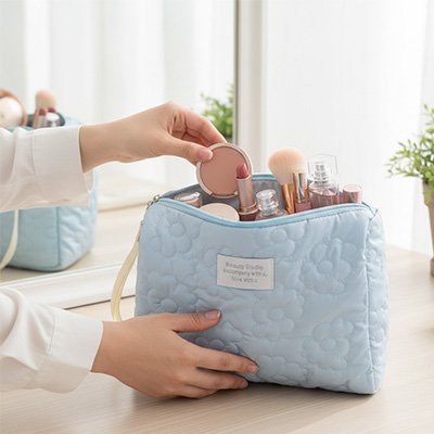 Présentation de la magnifique trousse à maquillage bleu et matelassé sur belle maquilleuse en bois blanc