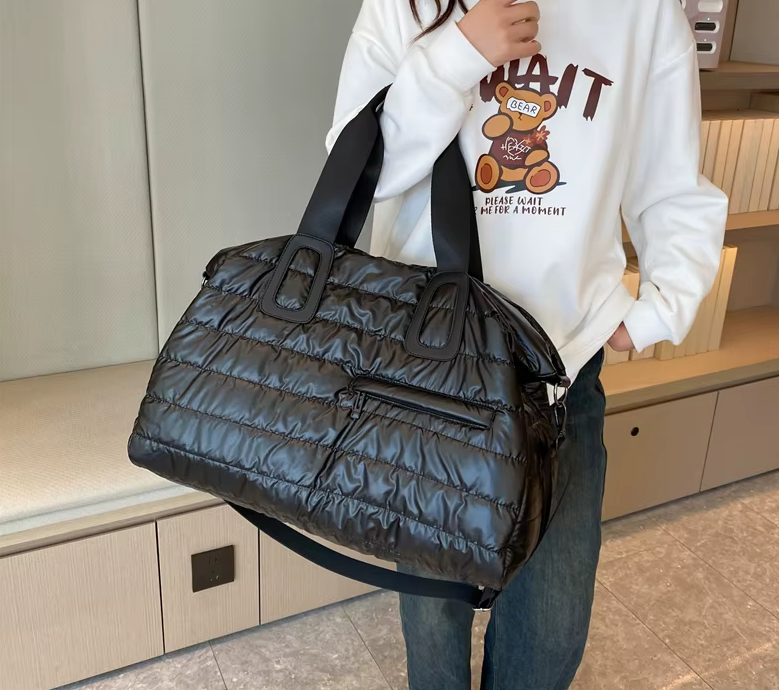 Présentation du grand sac week end noir matelassé avec sa petite poche avant, idéal pour les courts séjours et la cabine