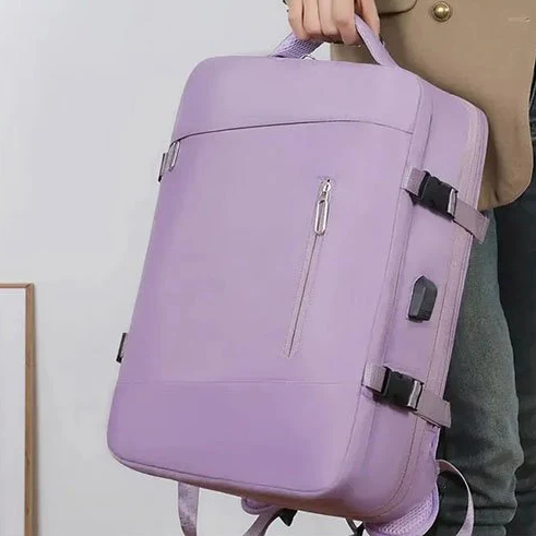 Présentation du sac à dos de voyage violet, tenu par la poignée