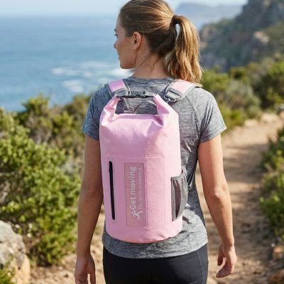 Randonneuse regarde la mer avec Sac à dos étanche en haut de magnifiques collines