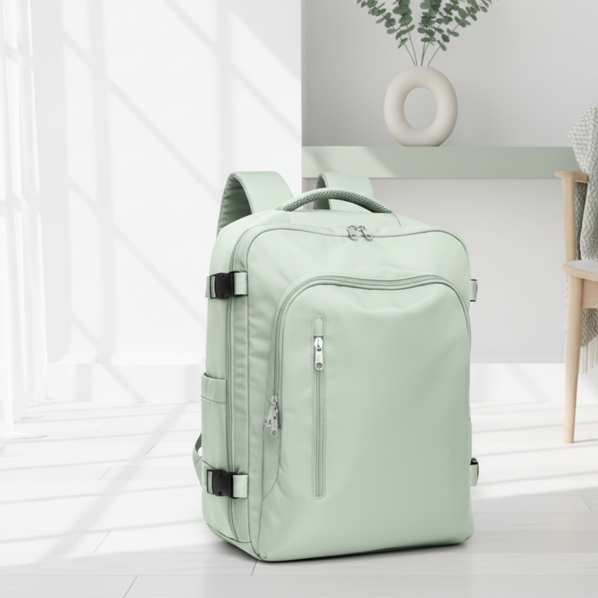 sac a dos avion compatible easyjet vert pâle sur le sol dans un salon blanc et petit chaise en bois.