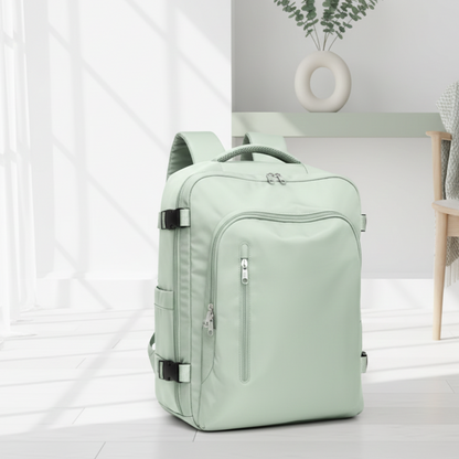 sac a dos avion compatible easyjet vert pâle sur le sol dans un salon blanc et petit chaise en bois.