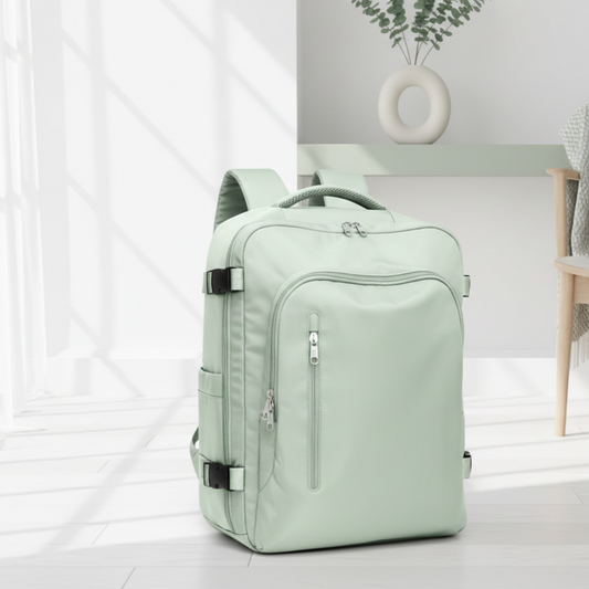 sac a dos avion compatible easyjet vert pâle sur le sol dans un salon blanc et petit chaise en bois.