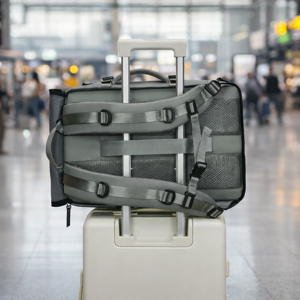 Sac à dos de voyage 40L vert armée fixé sur une valise dans un aéroport moderne. Sangles solides et format cabine pratique.