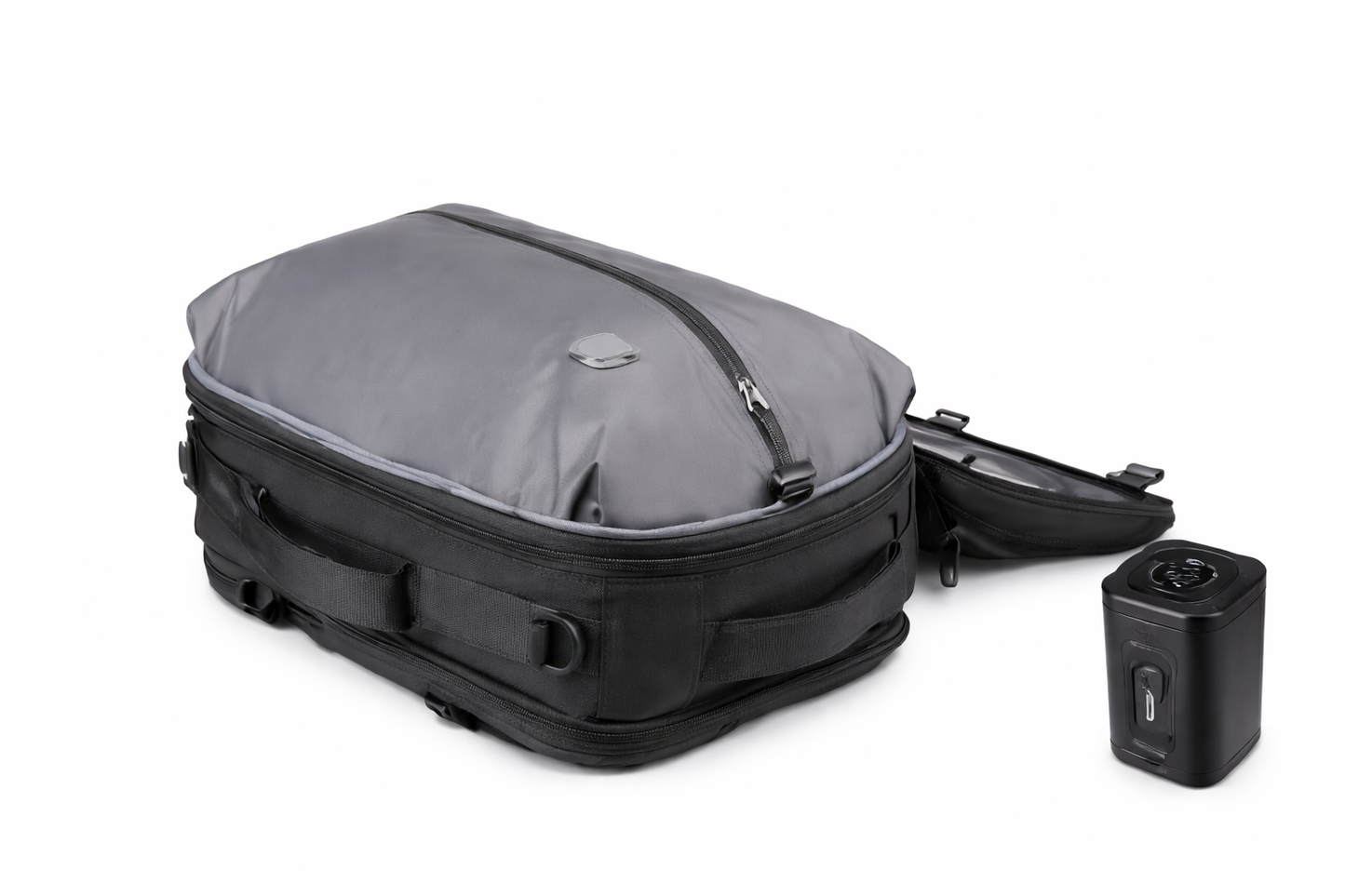 Sac de voyage à dos gris et noir posé sur fond blanc, montrant un design compact et structuré, accompagné d’un accessoire de compression pour optimiser le rangement.