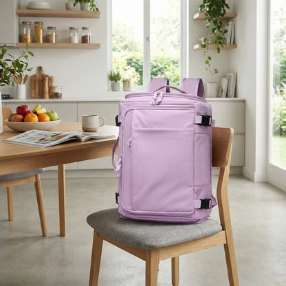 Sac de voyage à dos violet posé sur une chaise en bois avec coussin gris dans une cuisine lumineuse, créant une ambiance douce, moderne et adaptée au quotidien. sur la table on trouve café, revue et plat de fruits.