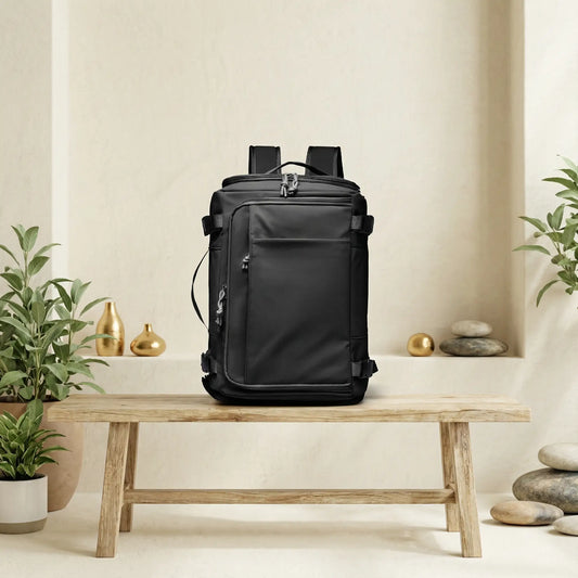 Sac de voyage à dos noir posé sur un banc en bois naturel dans un décor zen avec plante verte, mettant en valeur un design épuré et une allure moderne et élégante.