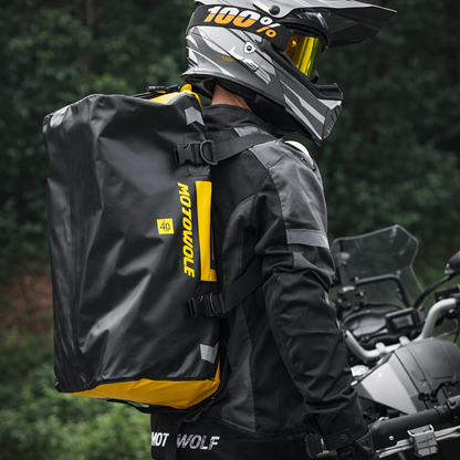 Sac week-end homme jaune porté en sac à dos par un motard équipé, forêt verdoyante autour. Ambiance aventure plein air, visibilité élevée et style fonctionnel.