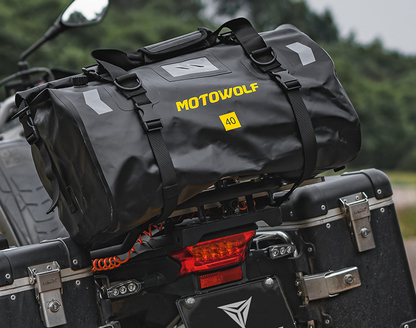 Sac week-end homme noir en gros plan montrant la texture imperméable et les coutures solides présenté sur la partie arrière d'une moto.