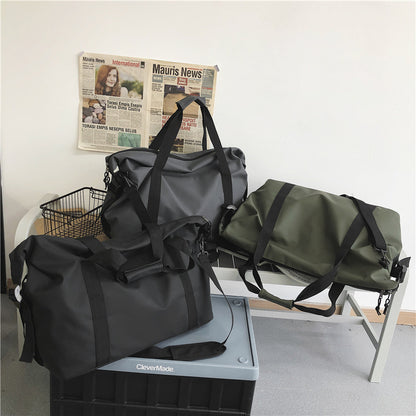 Sac week end noir gris et vert présentes ensemble en intérieur sur du mobilier pour montrer la collection sur un banc