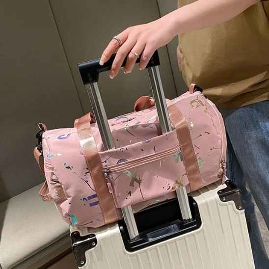 Sac Weekend Fantaisie rose fixé sur une valise cabine, pratique et élégant pour les voyages courts et déplacements fréquents.