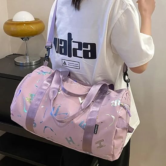 Sac Weekend Fantaisie rose porté à l’épaule par une femme, style urbain et pratique, idéal pour escapades et déplacements quotidiens.
