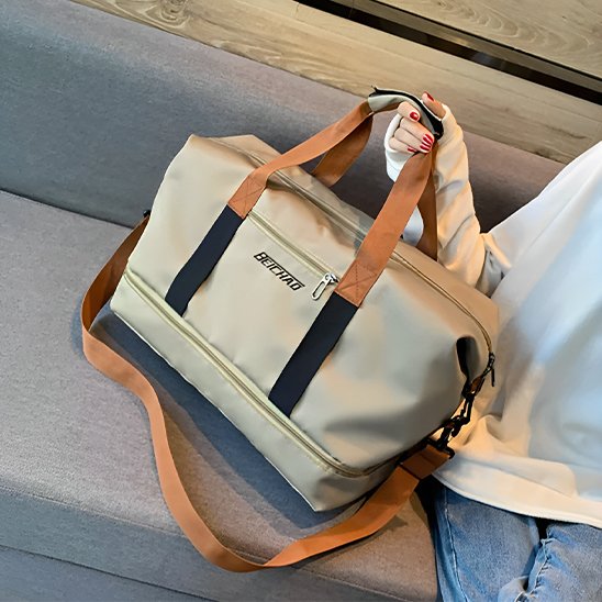 sac weekender beige avec poignées marron tenu par une femme banc gris