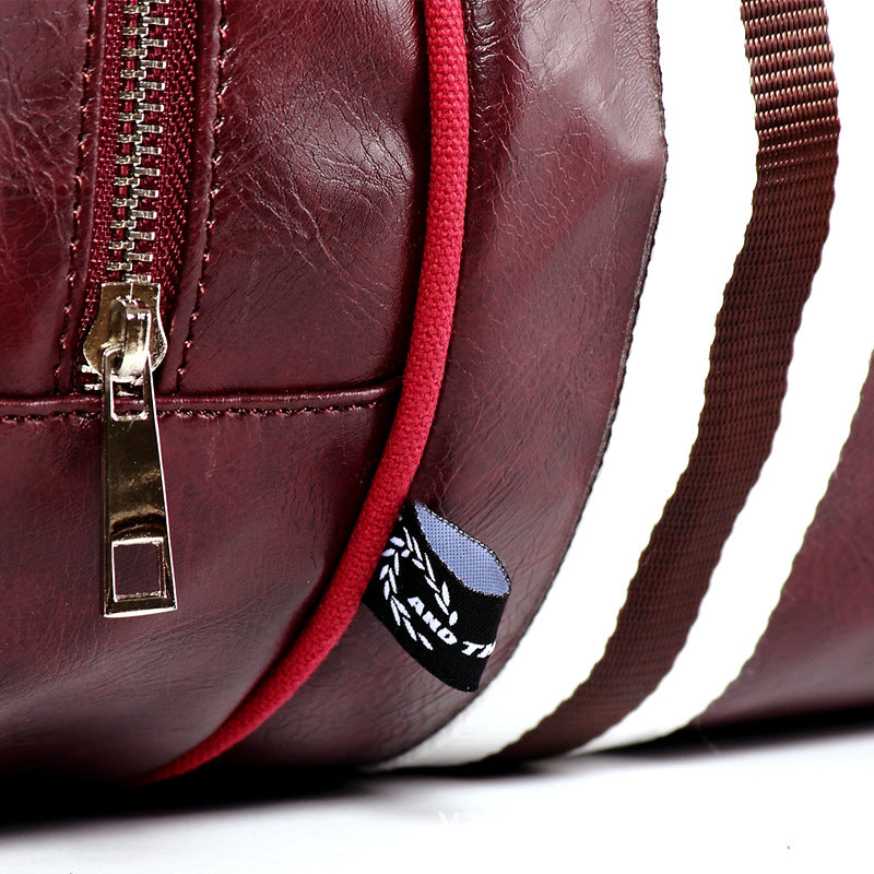 Détail en gros plan d’un sac weekender homme bordeaux montrant la fermeture éclair et la texture effet cuir véritable
