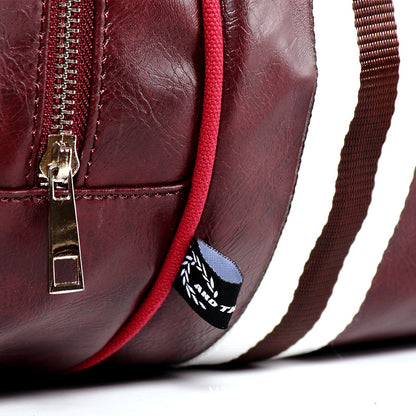 Détail en gros plan d’un sac weekender homme bordeaux montrant la fermeture éclair et la texture effet cuir véritable
